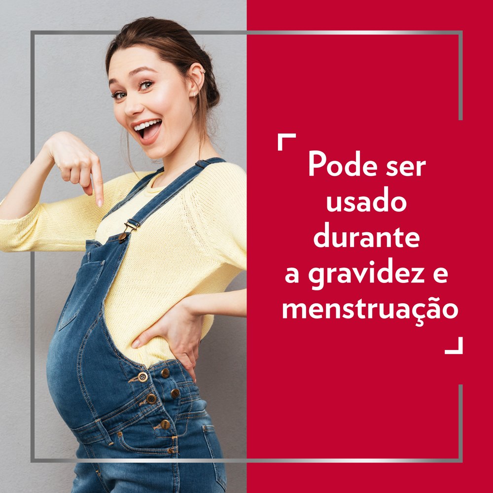 Jovem mulher grávida feliz com jardineitas de ganga e blusa amarela, apontando para a barriga e com legenda no lado direito da imagem: Pode ser usado durante a gravidez e menstruação.